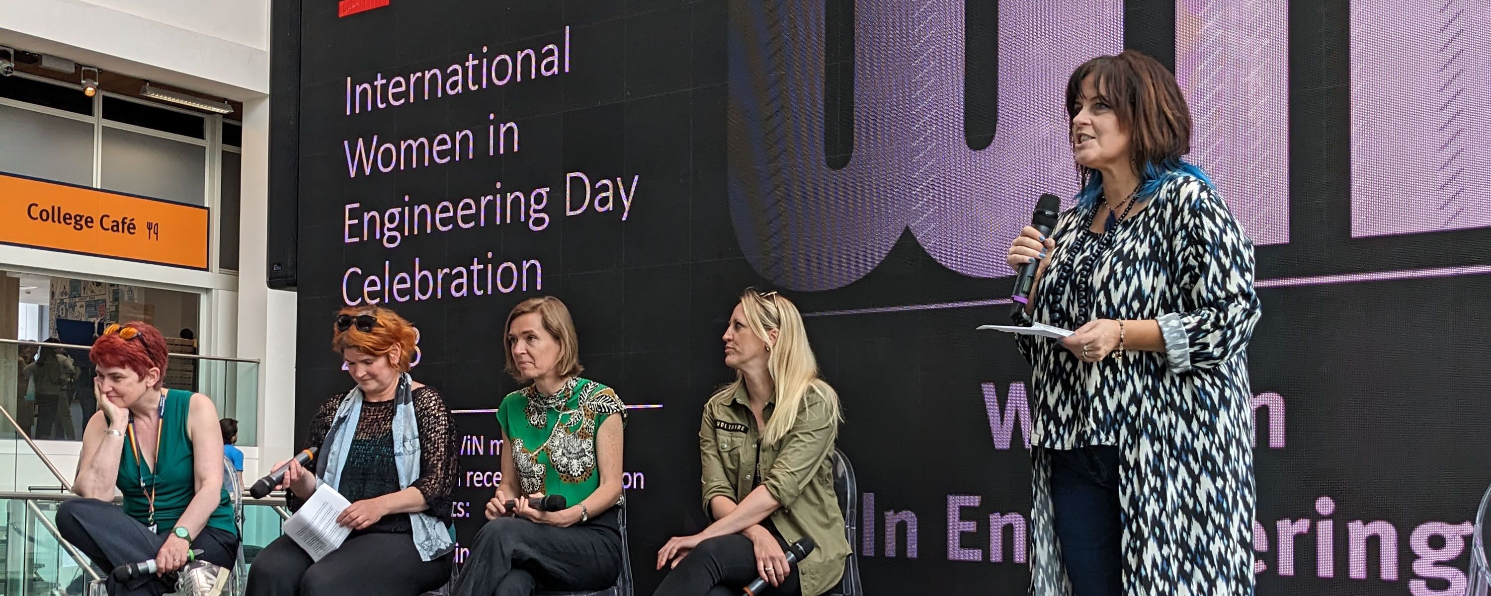 Julie McCann introducing a panel of women on stage