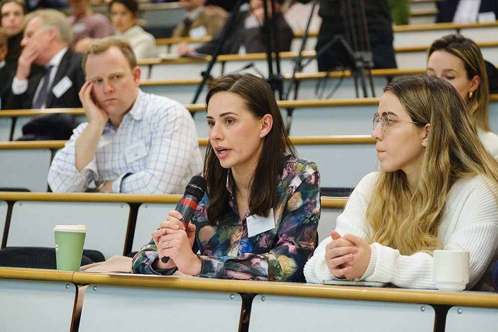 Woman in audience asks question into microphone