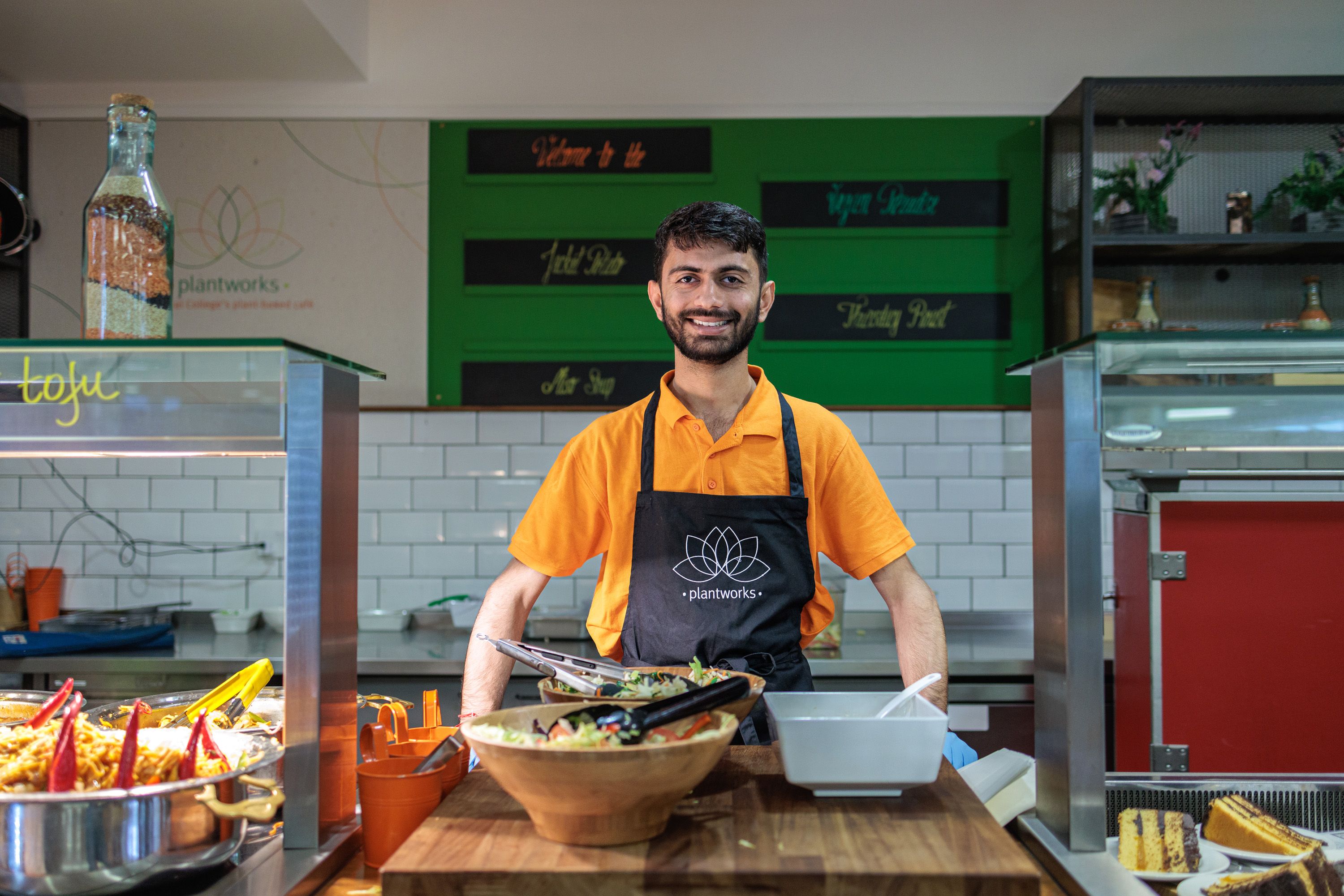 Member of catering staff Mishal Cava smiling behind the counter in an Imperial café