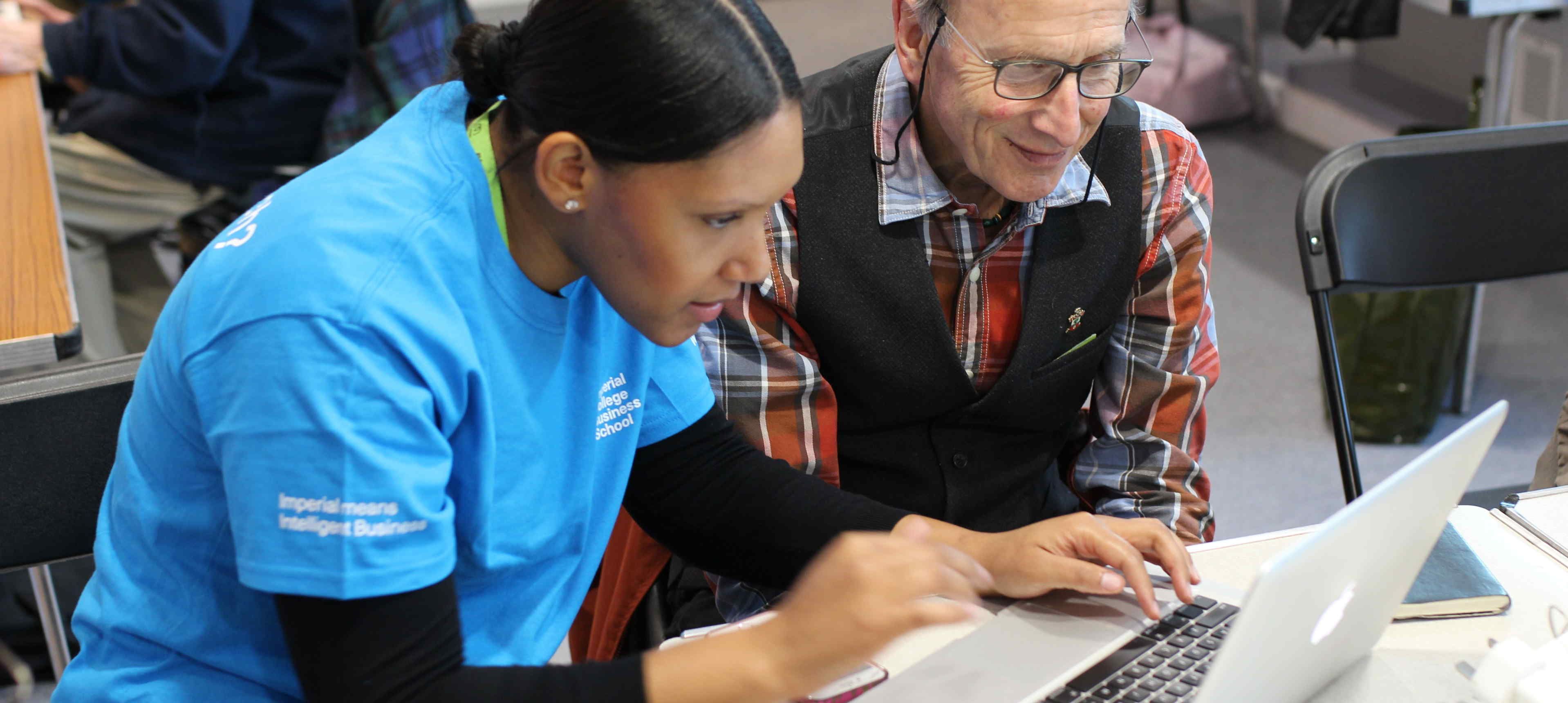 A local resident being helped with their laptop at What the Tech