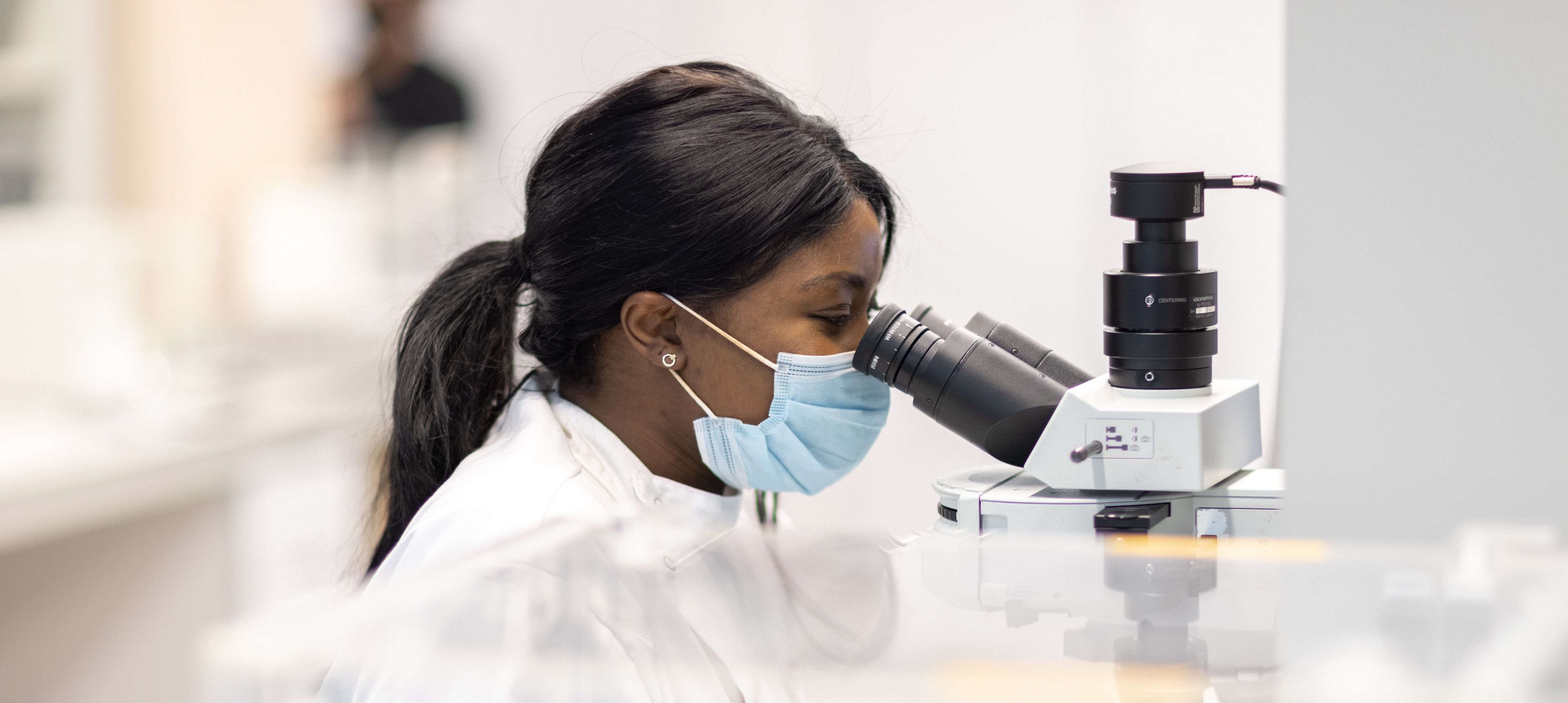 Researcher looking through a microscope