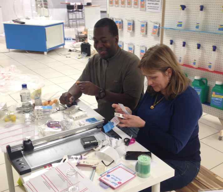 Two people sit a desk making exhibits