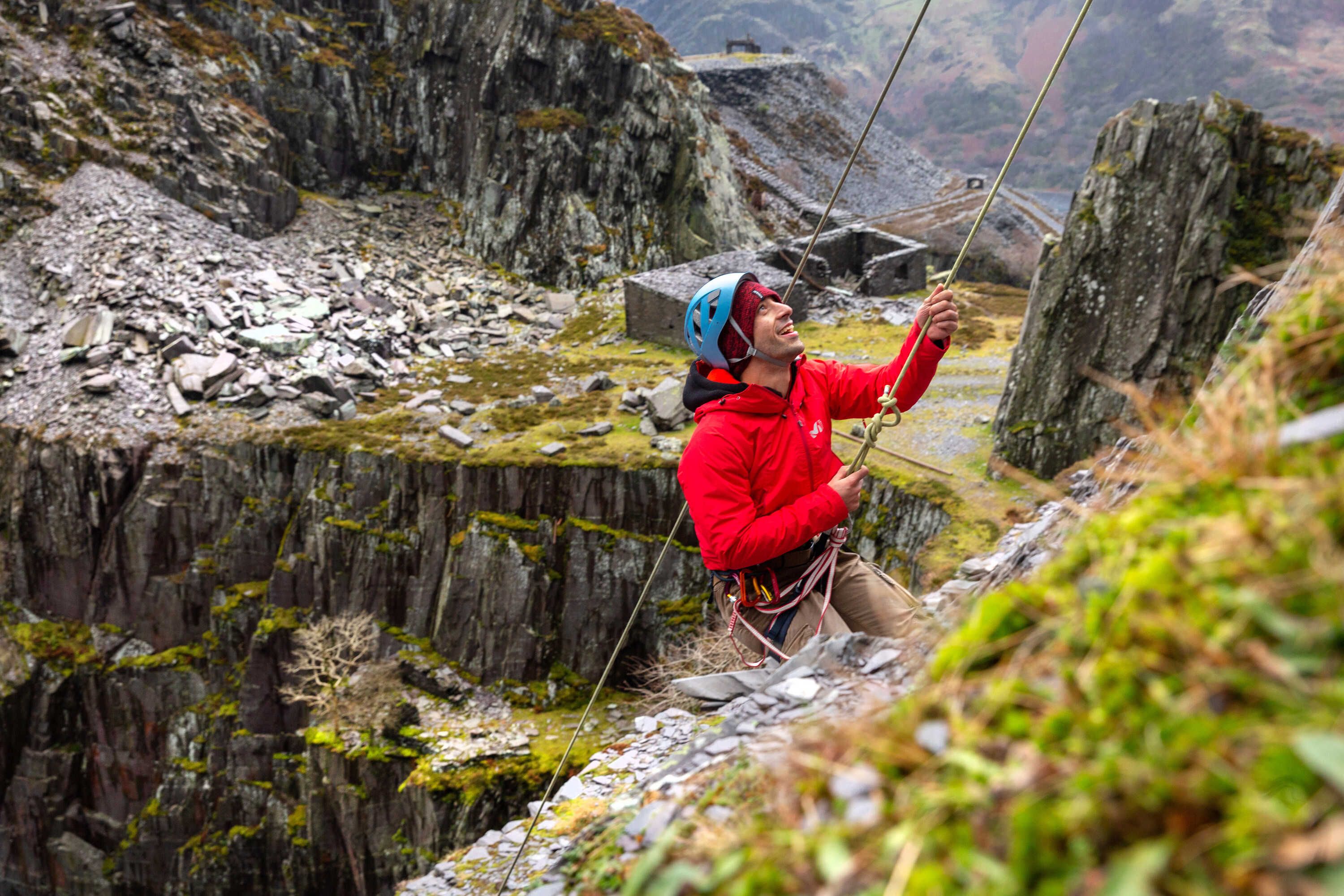 A student climbing a rock face in Snowdonia