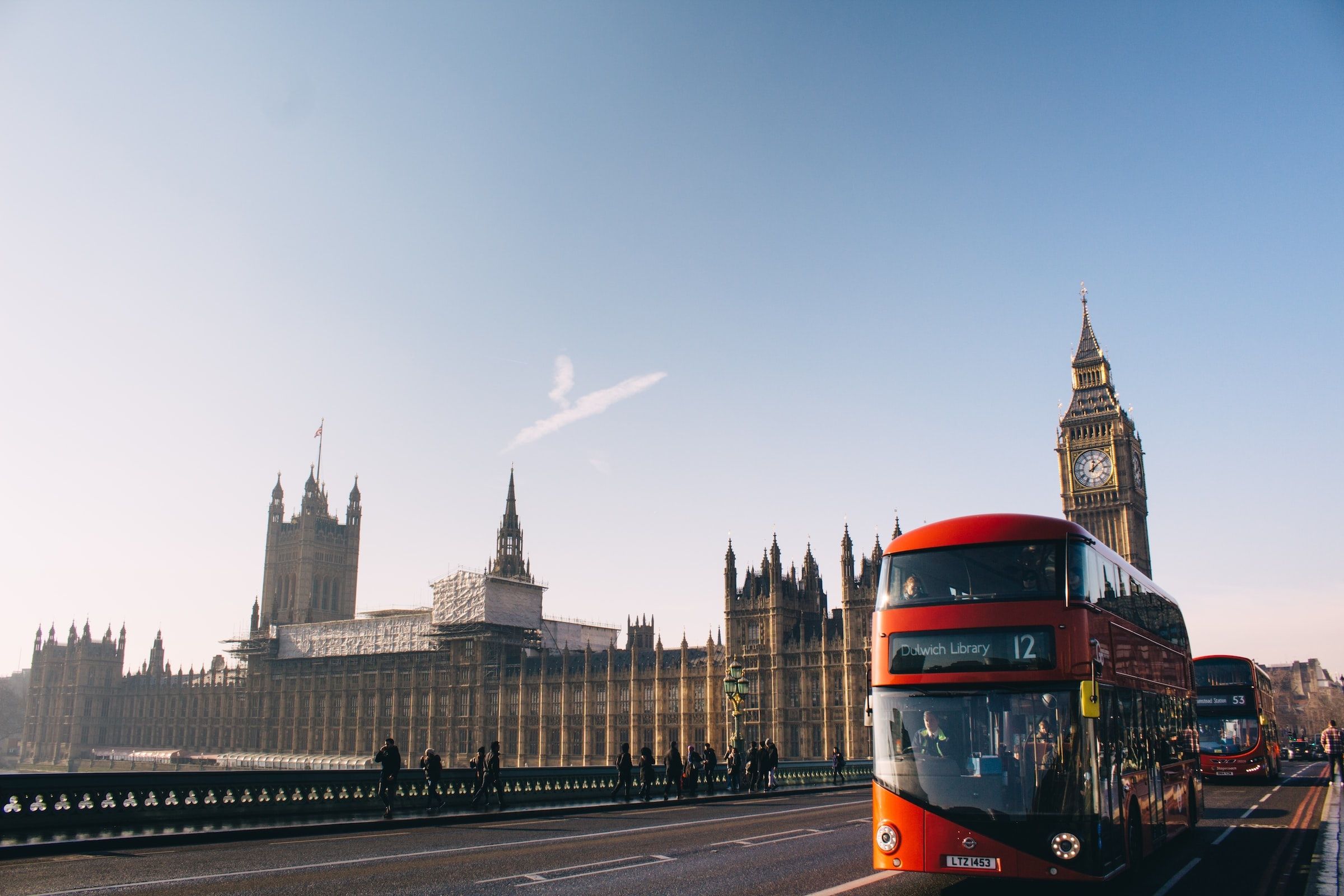 A red bus driving over Westminster bridge