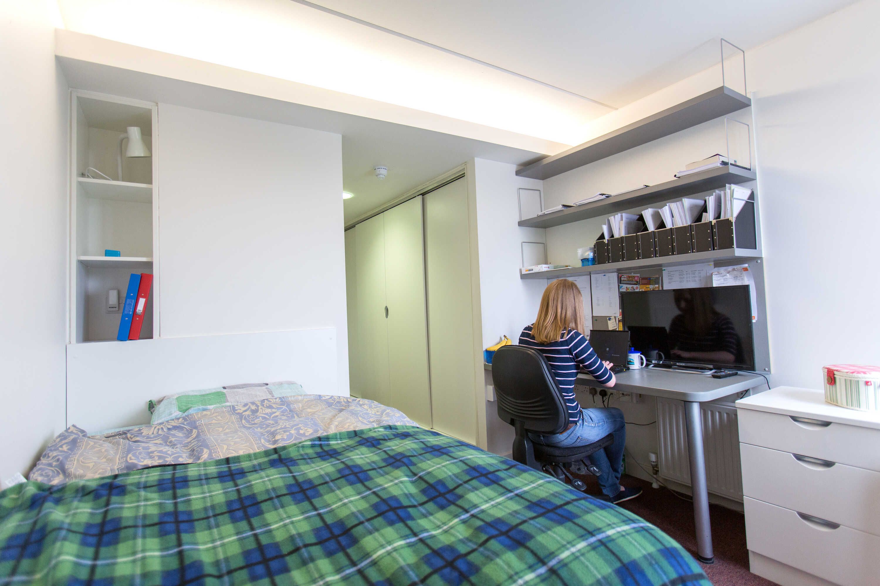 A student working in her bedroom in Eastside Halls of residence