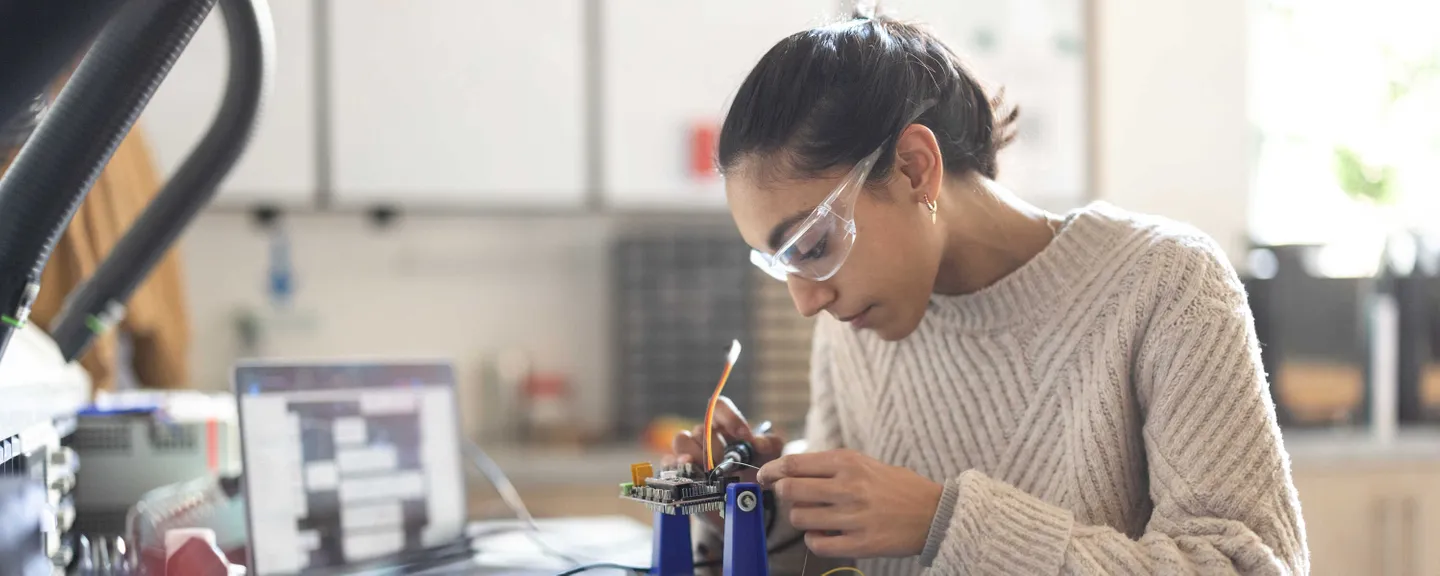 Student working at a bench on a design engineering project