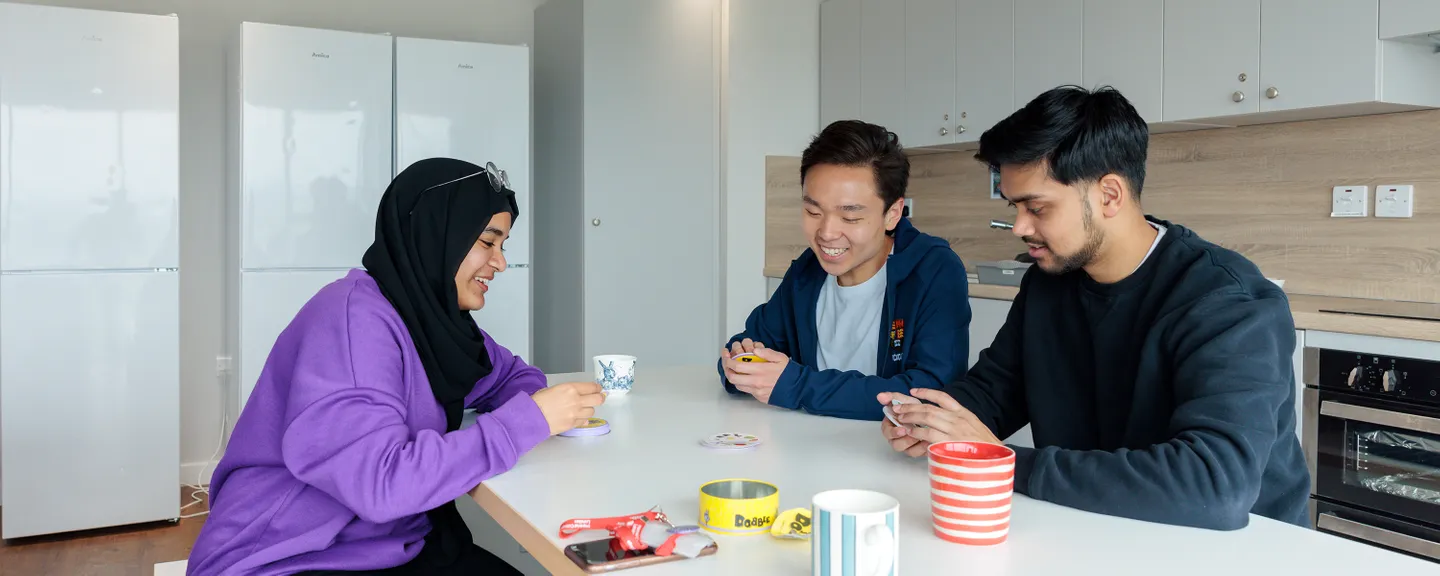 Students drinking and playing games in kitchen