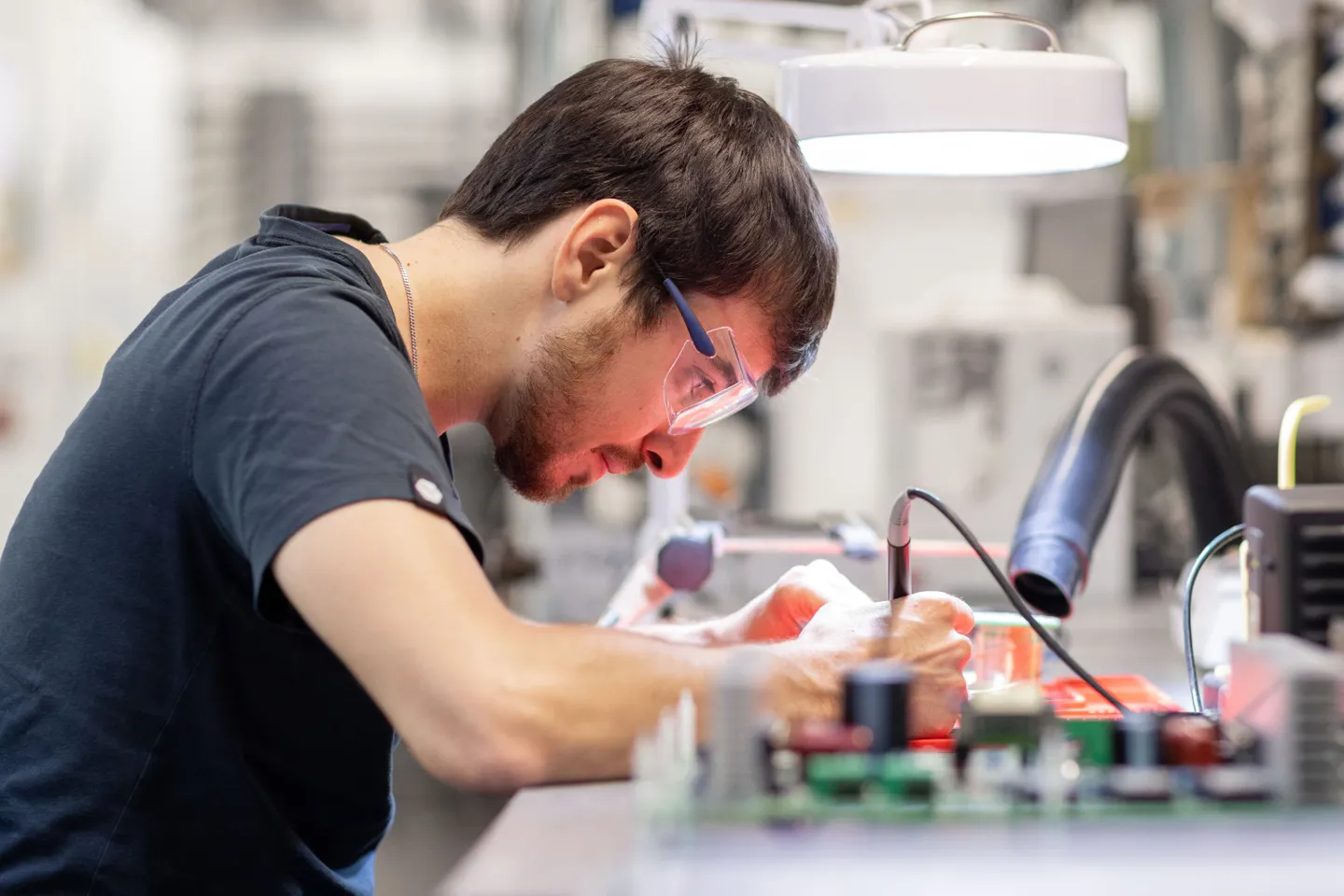 A student wearing goggles working on an experiment