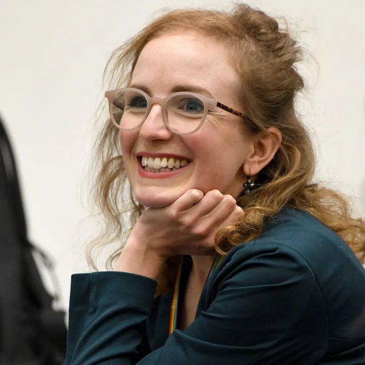 A woman smiling with her chin on her hand