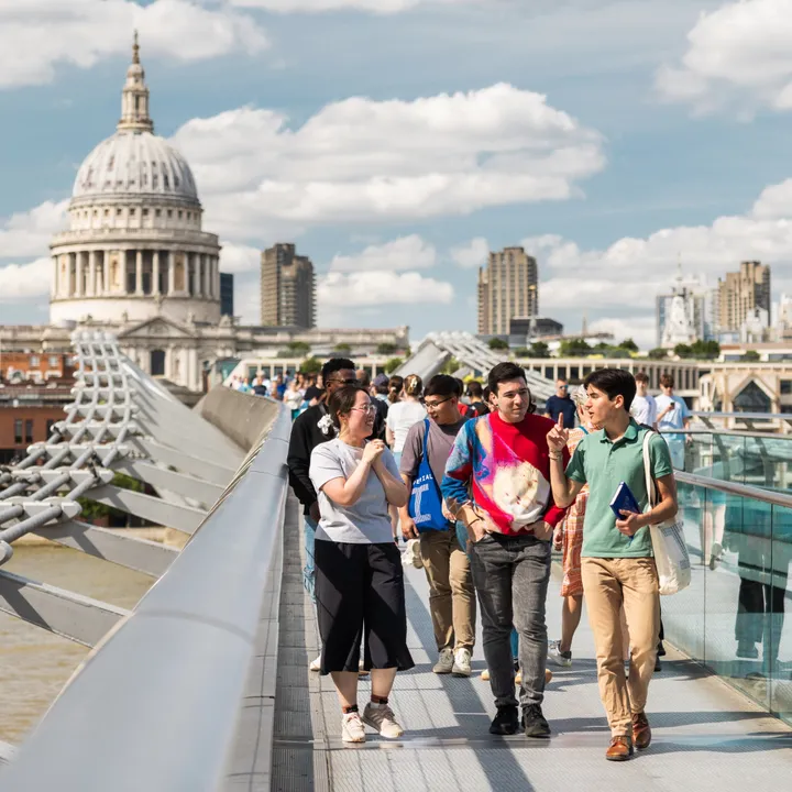 Students walking on the Millennium Bridge in London with St Paul's Cathedral in the background