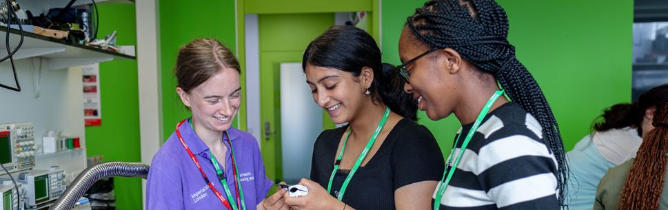 Student ambassador supporting two summer school students in the engineering workshop