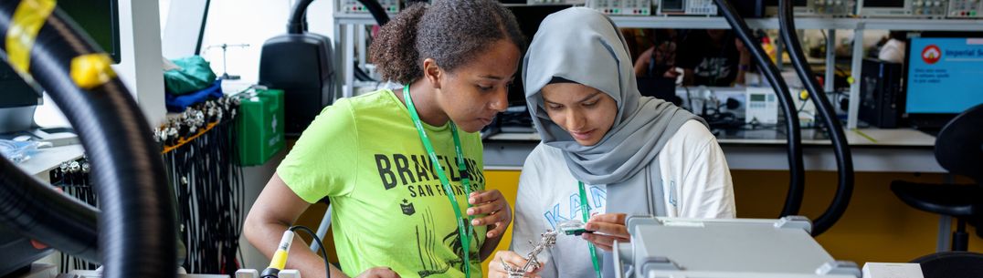 Two students in EE lab looking at equipment