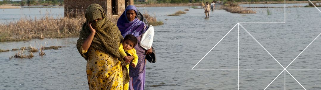 Women with a baby walking along a flood