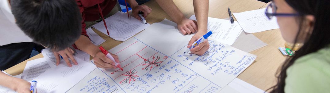 group of student solving maths equations on paper