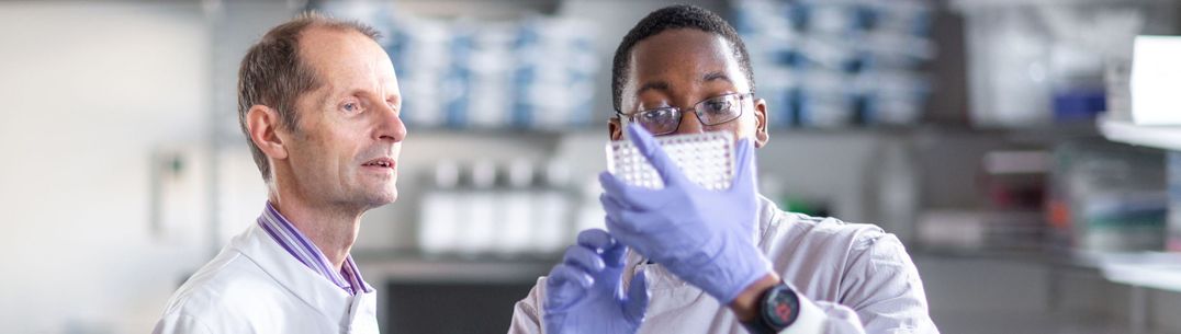 Professor Robin Shattock and a researcher look at samples in the lab