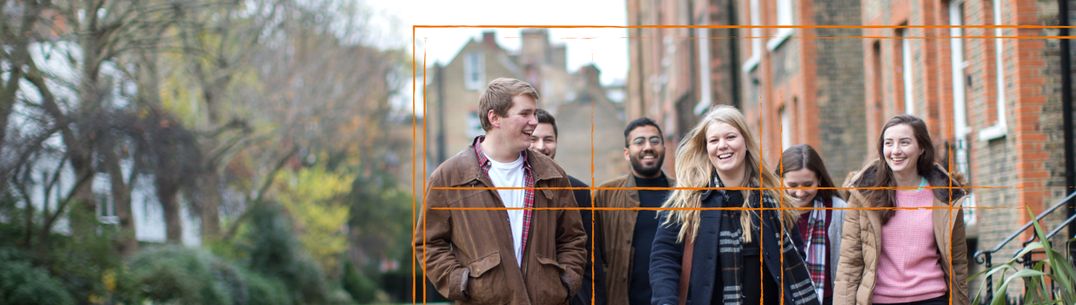 A group of students walk by Evelyn Gardens with window graphic overlay