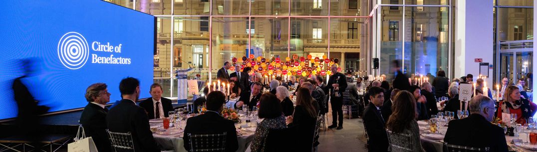 Launch party for the Circle of Benefactors, with guests enjoying dinner in the foreground and donor installation in the background
