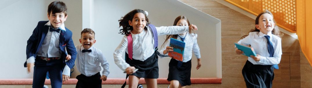 Children in school uniform running towards the camera