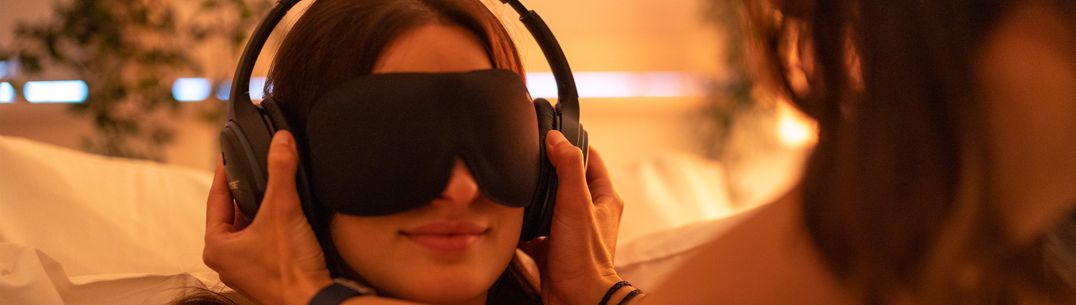 An image of a patient being fitted with a sleep mask and headphones for psychedelic research therapy