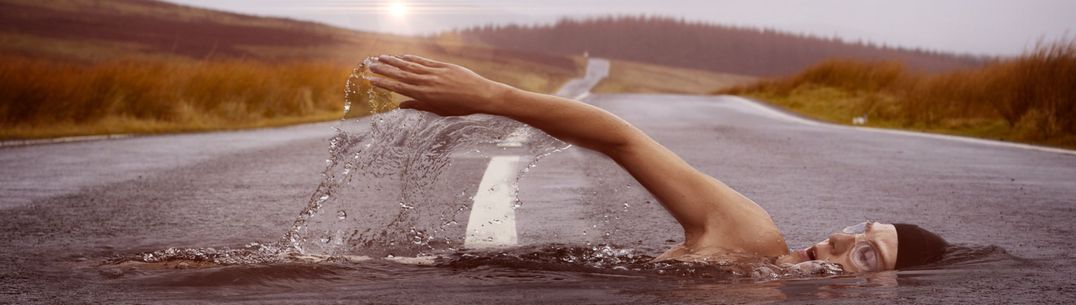 Abstract image of person swimming through a quiet tarmac country road
