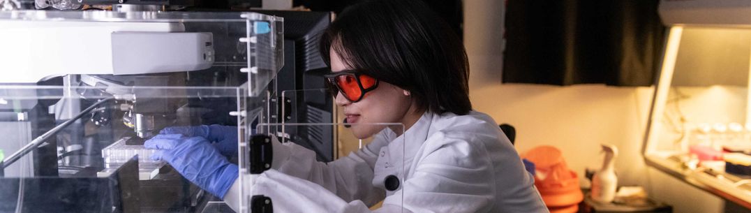 Photo of Dr Jang-Ah Kim using equipment and wearing PPE in the lab