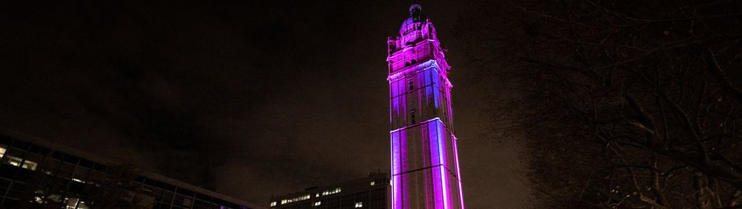 Photo of Queen's Tower lit up in purple