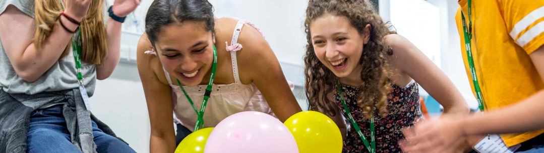 Year 9 girls laughing while taking part in an experiment.