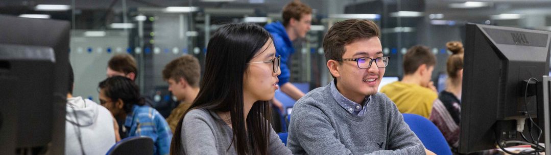 Two students looking at a computer monitor