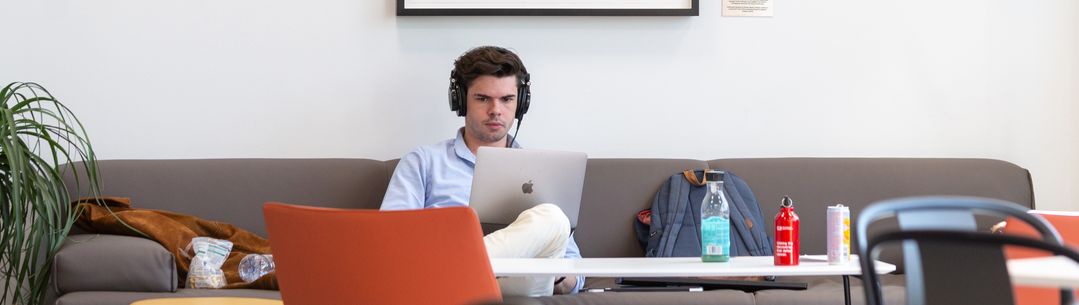 Man working at a laptop wearing headphones