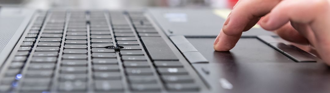 Close up photo of hands typing on a laptop keyboard