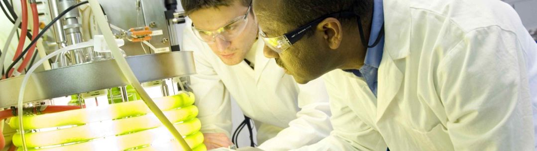 Two researchers looking at a glowing coil