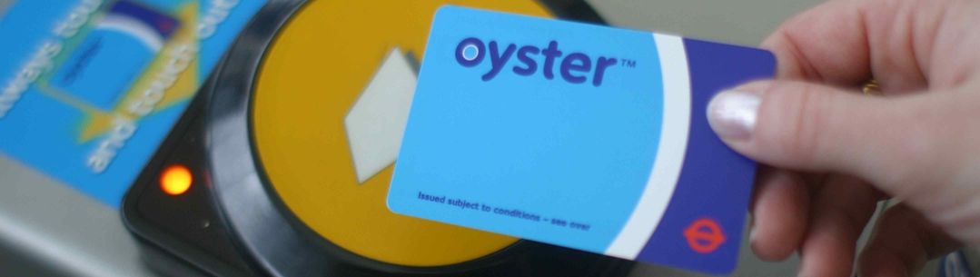 Person holding Oyster card over card reader