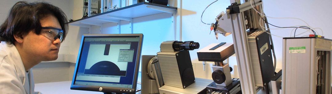 A male researcher initiate lab equipment through a computer