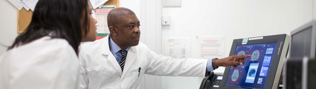 student and professor pointing to a screen