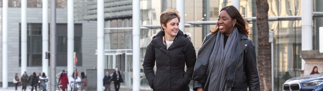 Two students walking in front of the South Kensington Campus