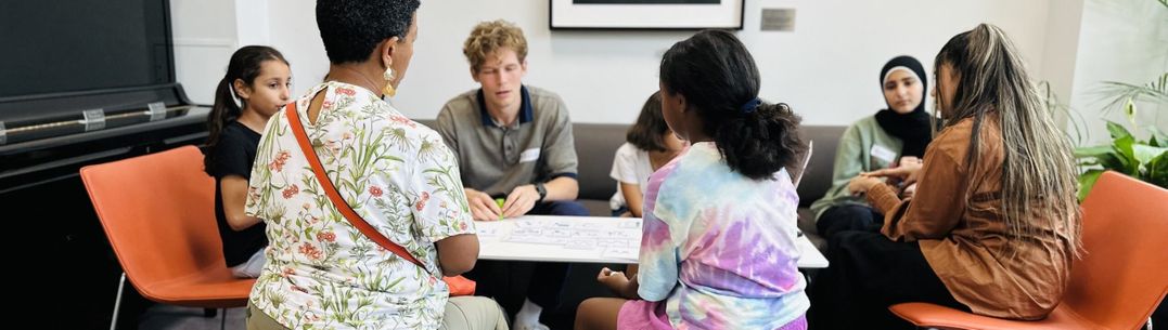 A group of kids with a parent and 2 Imperial scientists discuss quantum concepts