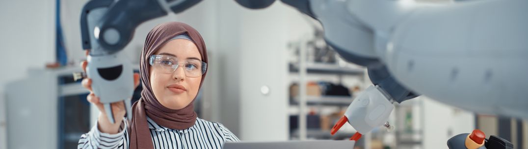 A picture of a research working with a robot in a lab