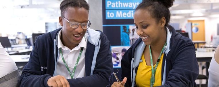 Two school students practice suturing as part of the Pathways to Medicine scheme