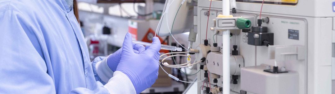 Scientist injects fuild into a machine of testing