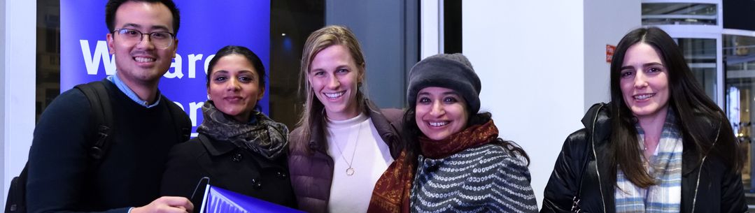 Group of five alumni smile at the camera