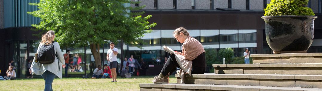 Student reading on campus 