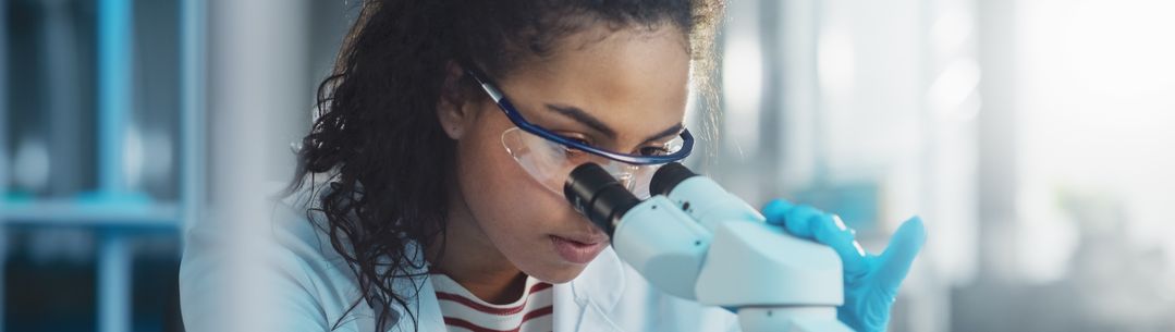 student looking through microscope