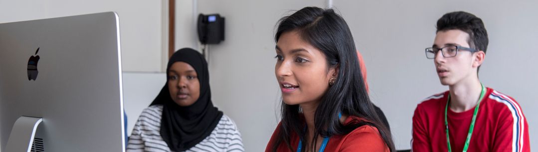 Students seated around a computer on the Pathways to medicine programme.