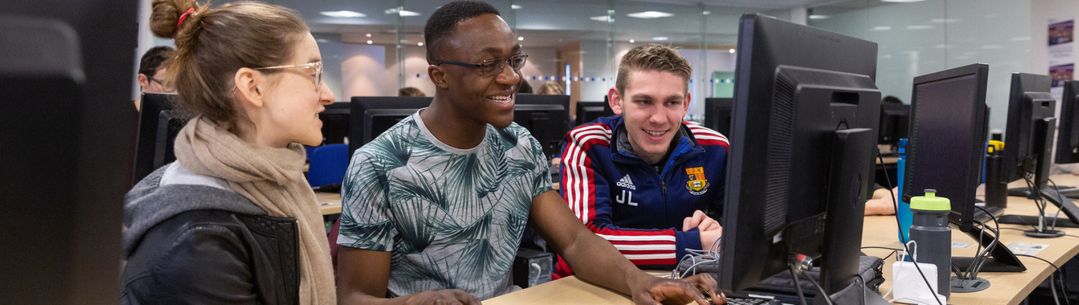 Three students working on a computer