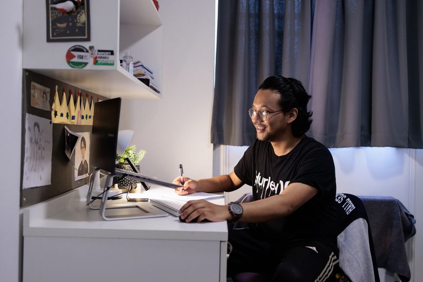 A student writing at a desk