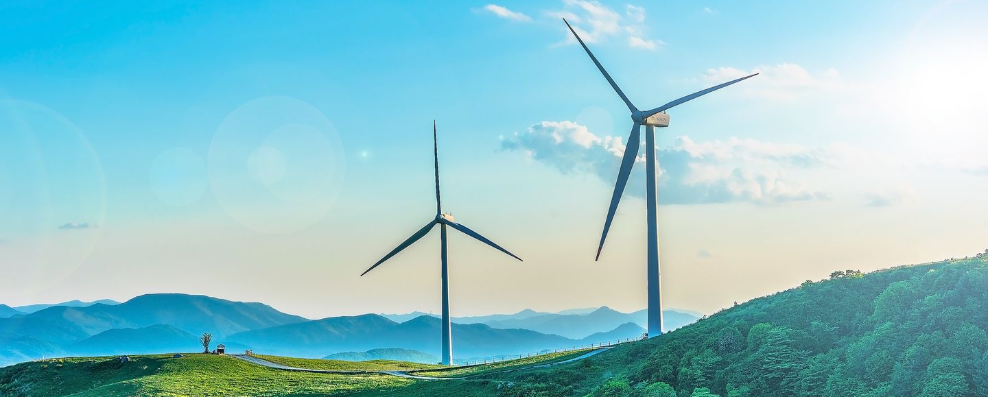 Two wind turbines situated amongst hills