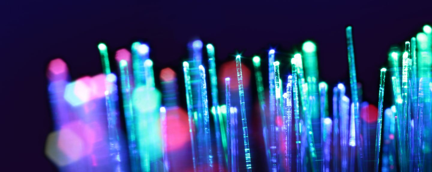 Colourful fibre optics in front of a dark navy background