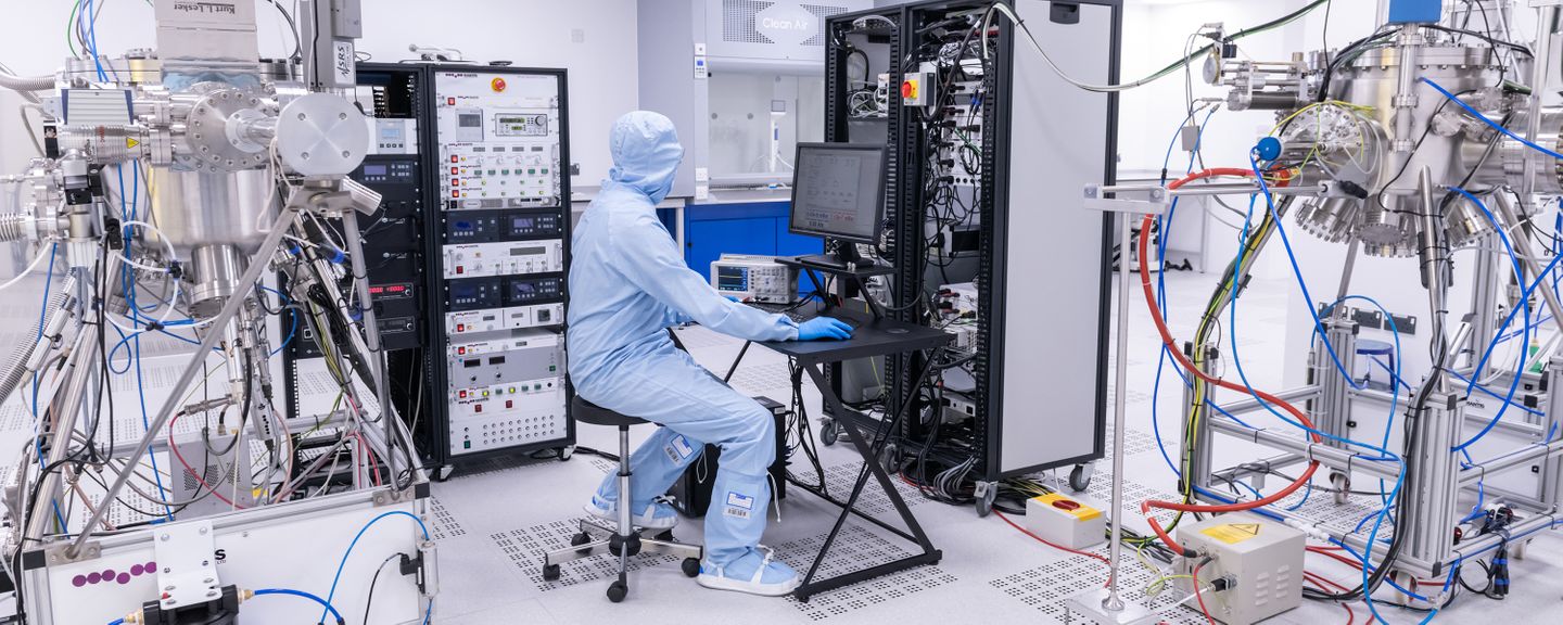 A person in a protective suit surrounded by advanced equipment