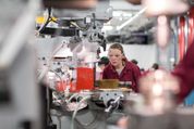 Student in overalls working in the mechanical engineering workshop