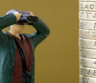 A person looking at coins through binoculars